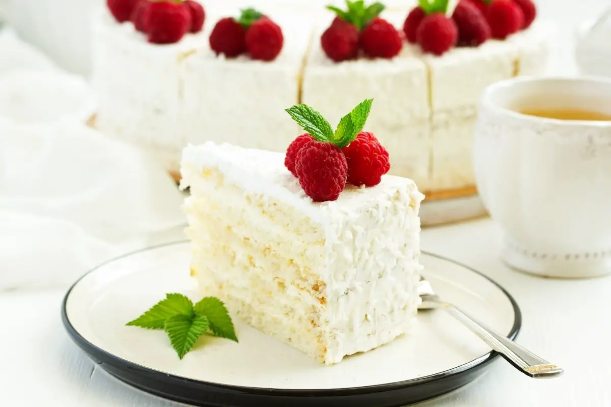 Incroyable gâteau blanc fourré aux framboises et glaçage à la crème fouettée